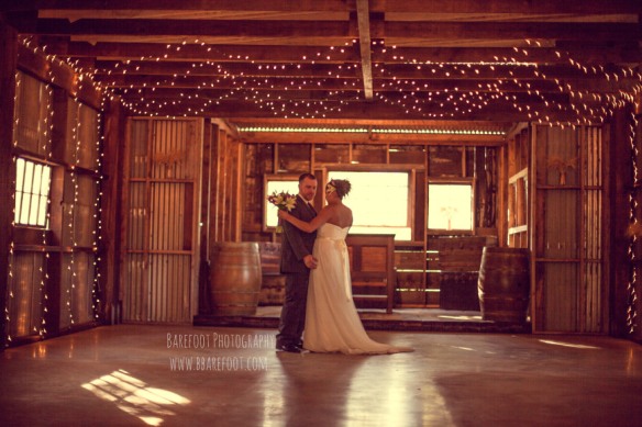 bride and groom posing in barn